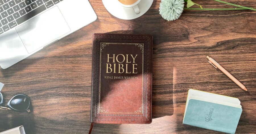 flat lay of the holy bible and items on the desk